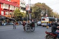 An unidentified man and his rickshaw and an unidentified woman crosses the road at a traffic stop in Kolkata, India