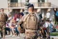 unidentified Man in military uniform and with a military weapon patrolling the streets of the city during a public event