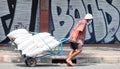 Unidentified man pulls a heavily loaded handcart