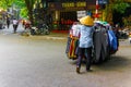 Unidentified man pushes shopping cart with clothes in Hanoi, Vietnam.