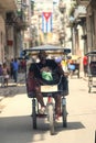 Unidentified man riding a pedicap known as a bicitaxi at cuba