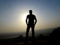 An unidentified man standing on top of a hill mountain peak at the time of sunset silhouette photograph , freedom conceptual , spa Royalty Free Stock Photo