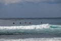 Unidentified man on surf board waiting for wave in blue water back view. Young Boys Waits the Waves. Surfer waiting in line for a Royalty Free Stock Photo