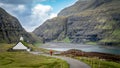 Unidentified man walking towards church from village of Saksun, Faroe Islands, Denmark Royalty Free Stock Photo