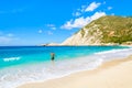 Unidentified man walking into turquoise sea water on Petani beach, Kefalonia island, Greece