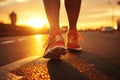 An unidentified man walks in red sneakers on the asphalt towards the sunset. The concept of the big way Royalty Free Stock Photo