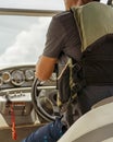 Unidentified man wearing life jacket driving speedboat