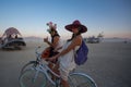 Unidentified man and woman riding a bicycle