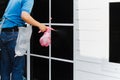 Unidentified man wrapper tinting a window with tinted foil using foggy spray.