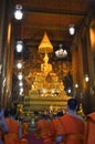 Unidentified monks pray at a Buddah statue