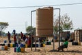 Unidentified Namibian woman with child near public tank with drinking water.