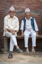 Unidentified Newari elderly men sit in front of the Mul Chowk Royal Palace in Patan Durbar Square - Nepal