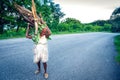 Unidentified older woman carying wooden branches on road, near Paraiso, Dominican Republic
