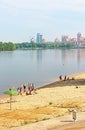 Unidentified people are resting on the beach of Dnipr river in Obolon district