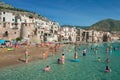 Unidentified people on sandy beach in Cefalu, Sicily, Italy