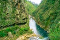 An unidentified people walking in natural walkway Karangahake Gorge, river flowing through Karangahake gorge surrounded