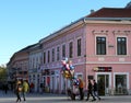 Unidentified People walking by the Old Pink Building and Balloon Seller. November 16,2023 in Novi Sad, Serbia