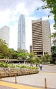 Unidentified people are walking in the park near skyscrapers in Hong Kong