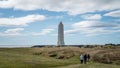 Unidentified people walking towards Malarrif Lighthouse on the Snaefelssnes Peninsula in Iceland