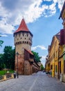 Unidentified people wander along the medieval defense wall and The Carpenters' Tower in Sibiu city, Transylvania Royalty Free Stock Photo