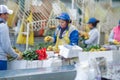 Unidentified people working inside of a flower factory on bunch of blossoming beautiful roses bouquets, empaqued and