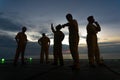 Unidentified people working oil and gas industrial enjoy the moment during sunset. Royalty Free Stock Photo