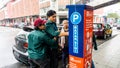 Unidentified persons using the parking ticket payment machine at the side of the road Royalty Free Stock Photo