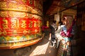 Unidentified pilgrimage near spinning Big Tibetan Buddhist prayer wheel at Boudhanath Stupa, Dec 20, 2013 in Kathmandu, Nepal.