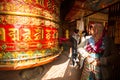 Unidentified pilgrimage near spinning Big Tibetan Buddhist prayer wheel at Boudhanath Stupa Royalty Free Stock Photo