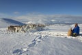 Unidentified Saami man brings food to reindeers in deep snow winter, Tromso region, Northern Norway. Royalty Free Stock Photo