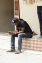 Unidentified Senegalese man plays on his cellphone.