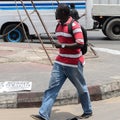 Unidentified Senegalese man in striped shirt with backpack walk