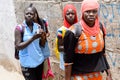 Unidentified Senegalese women in bright clothes walk along the