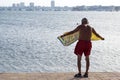 An unidentified senior retired man wearing swimsuit and towel at the beach