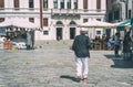 Unidentified senior tourist or local walking on the cobblestone alleys in Venice, Italy. Vintage picture