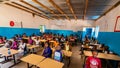 Unidentified serious and sad african children sitting at desks in a classroom in a primary school. New class with new desks, roof Royalty Free Stock Photo