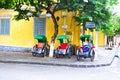 An unidentified service cyclo rider passing an ancient house