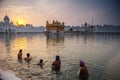 Unidentified Sikh men bath in the holy lake at Golden Temple