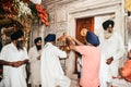 Unidentified sikh people decorating idol with ornaments and flower for final make up before Puja.