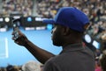 Unidentified spectator uses his cell phone to take images during tennis match at 2019 Australian Open in Melbourne Park Royalty Free Stock Photo