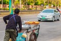 Unidentified street hawker pushing a mobile kitchen cart on a st