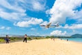 Unidentified tourists at Mai Khao beach with commercial aircraft landing at Phuket International Airport