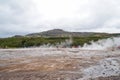 Unidentified tourists waiting for eruption of Strokkur Geysir,Iceland. Royalty Free Stock Photo