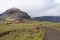 Unidentified tourists walking near Statue of Bardur Snaefellsnes,Iceland.