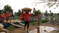 Trade union labourers unloading sacks of rice from a boat in the backwater region