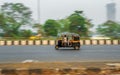 Unidentified tuk-tuk driver wearing a mask to protect from Covid-19 and driving famous black and yellow rickshaw, a public