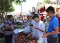 Unidentified Uzbek and Afghan immigrants buying red plums at the farmers market