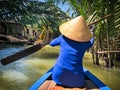 Unidentified Vietnamese woman paddling with foreign tourists on a traditional boat trip through the Mekong Delta in Vietnam. Royalty Free Stock Photo