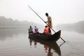 Villagers travel by a ferry boat to cross the river Pamba in a foggy morning