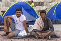 Unidentified war refugees near the tents. More than half are migrants from Syria